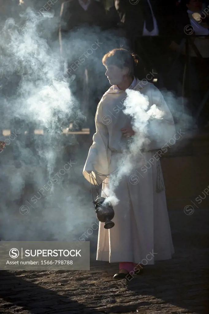 A female acolyte spreads incense during an Easter Holy Week procession in Prado del Rey, Andalusia, Spain, April 24, 2011