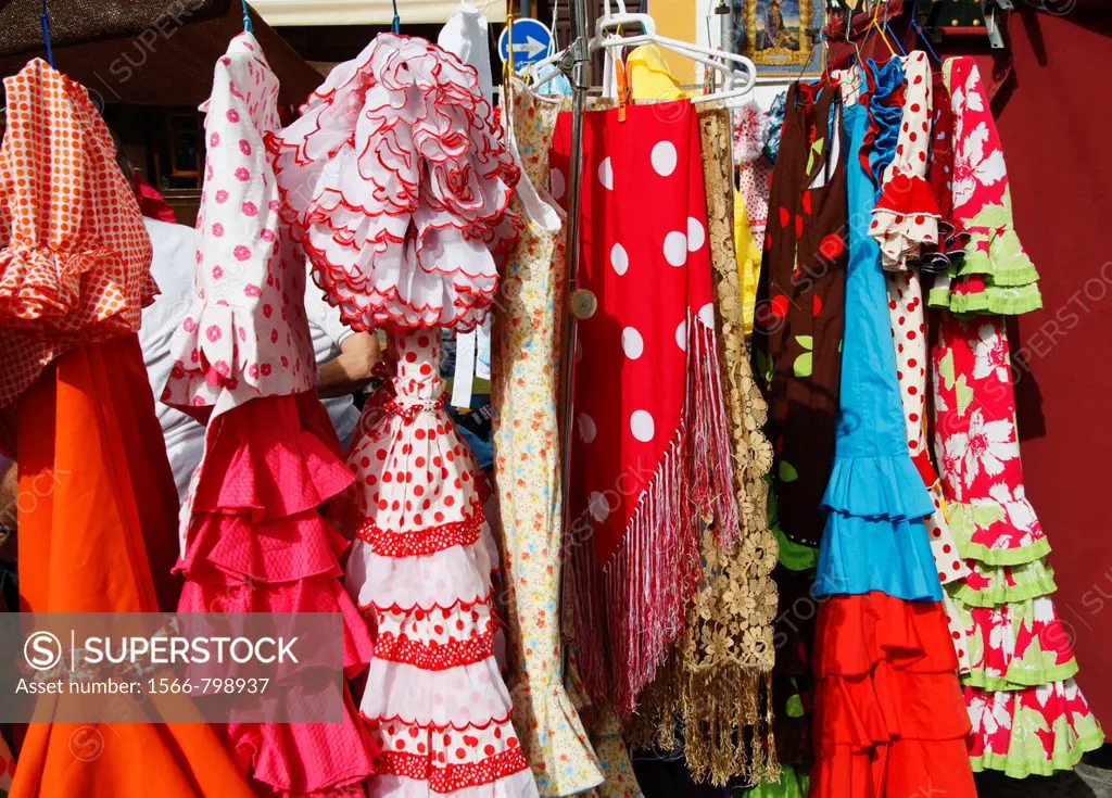 Flamenco dresses on market stall on famous street market in calle Ferria, in Barrio Macarena, Seville, Spain, Europe