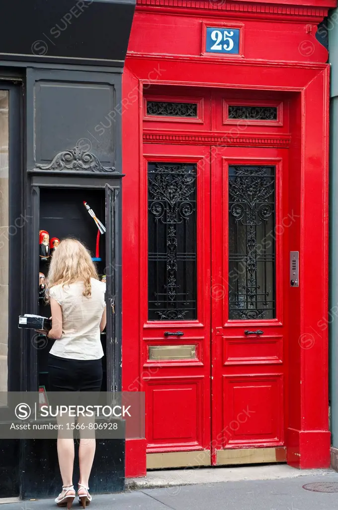 Street scene with with woman and red door, St Germain des Pres, Paris, France