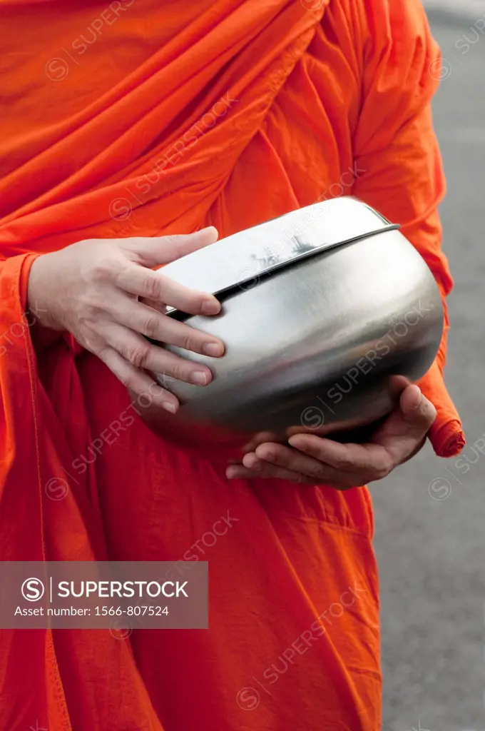 Monk with alms bowl waiting for alms in front of Wat Benjamabophit, Bangkok, Thailand
