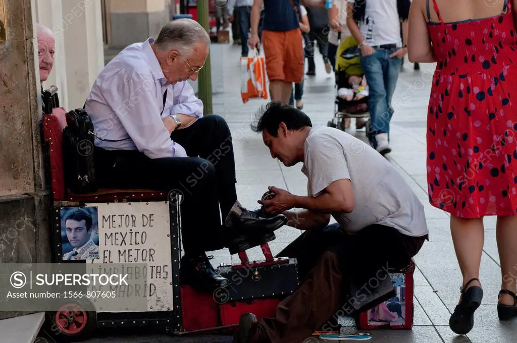 Mexican man polishes shoes on Gran Via, Madrid, Spain
