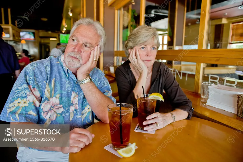 A middle aged couple appeared indifferent to each others´ company over iced tea together in a Long Beach, CA, restaurant