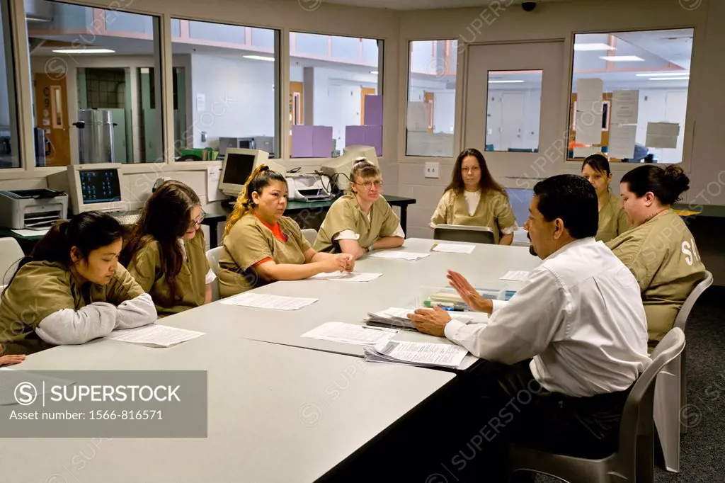 Uniformed women jail inmates participate in a drug treatment seminar with a Hispanic instructor in Santa Ana, CA  Note variety of ages and races