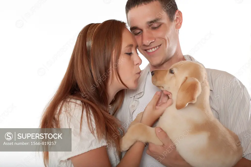 Young couple with labrador retriever puppy