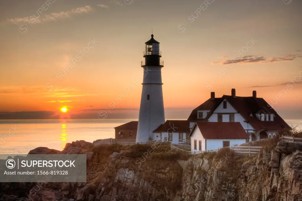 The first rays of sun after sunrise reach the Portland Head Light, built in 1791, which protects mariners entering Casco Bay. The lighthouse is locate...