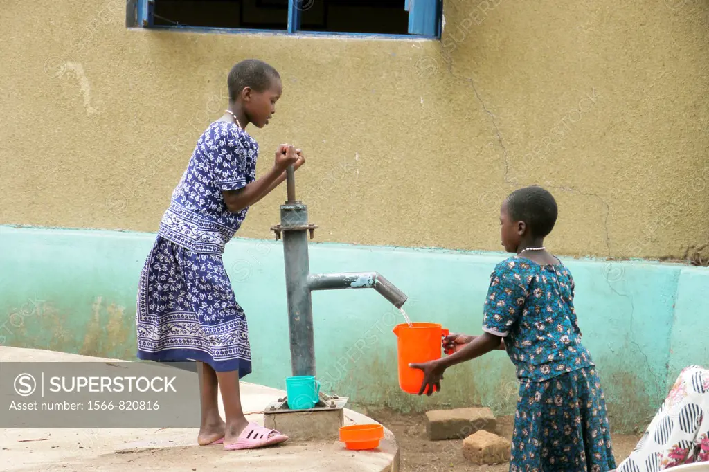 Girls collecting water from hand pump, Home of Compassion for the sick and needy, Kigera village, near Musoma, Tanzania