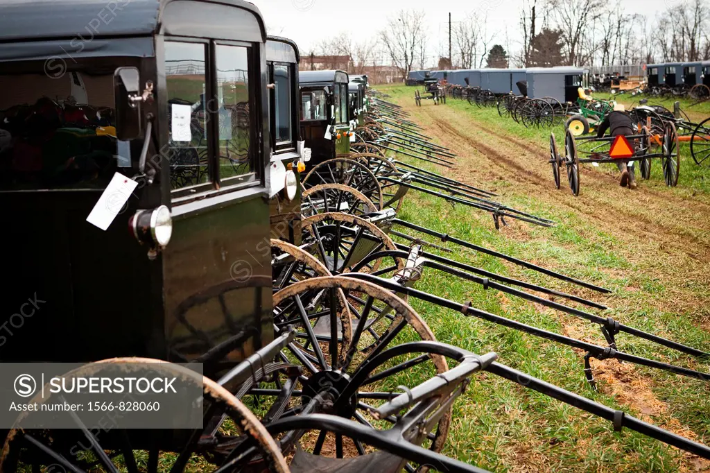Amish man pushes a buggy ready for auction during the Annual Mud Sale to support the Fire Department in Gordonville, PA