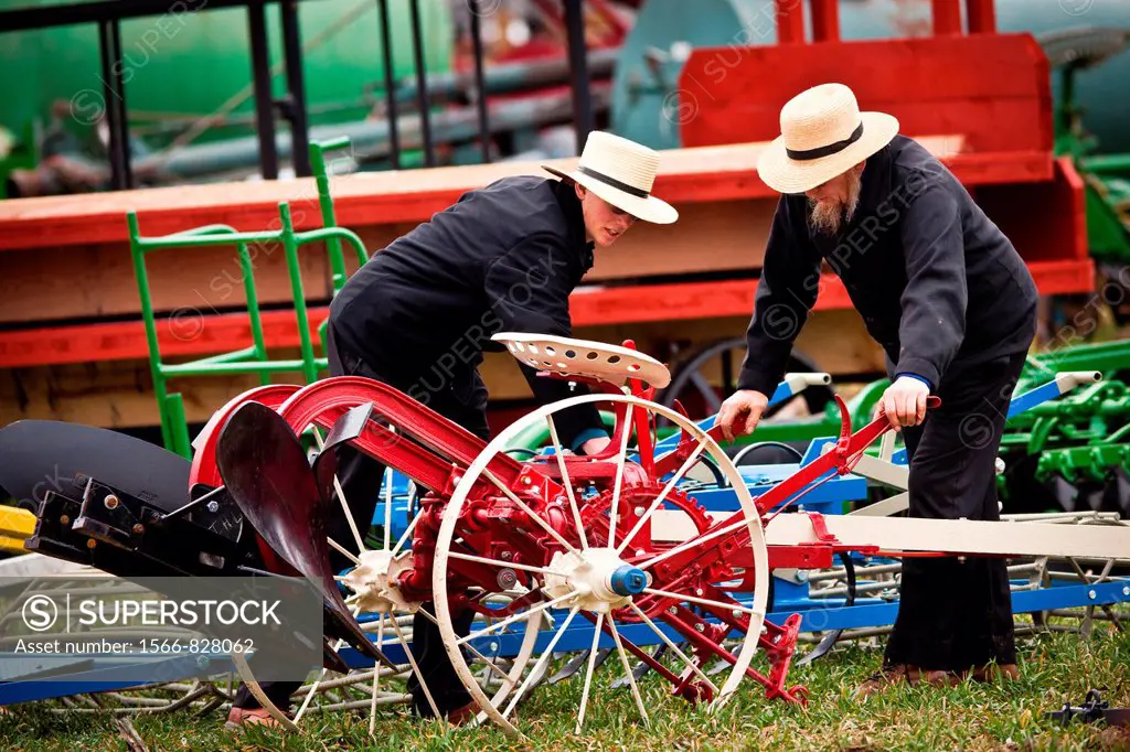 Amish men inspect farm equipment during the Annual Mud Sale to support the Fire Department in Gordonville, PA