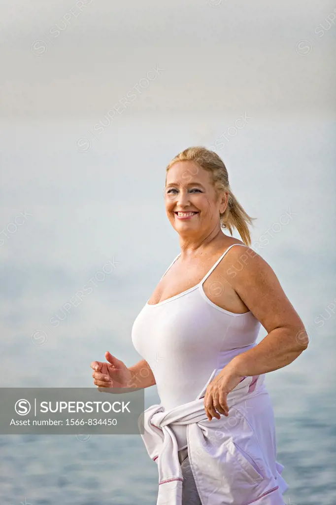 Portrait of a senior adult woman running at the beach