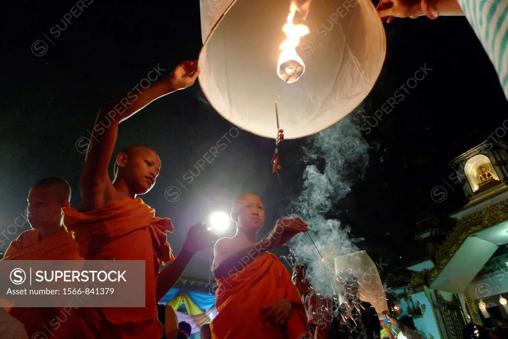 THAILAND  Chiang Mai  Loi Krathong lantern Festival  Buddhist monks and tourists lighting and launching lanterns which float in the sky