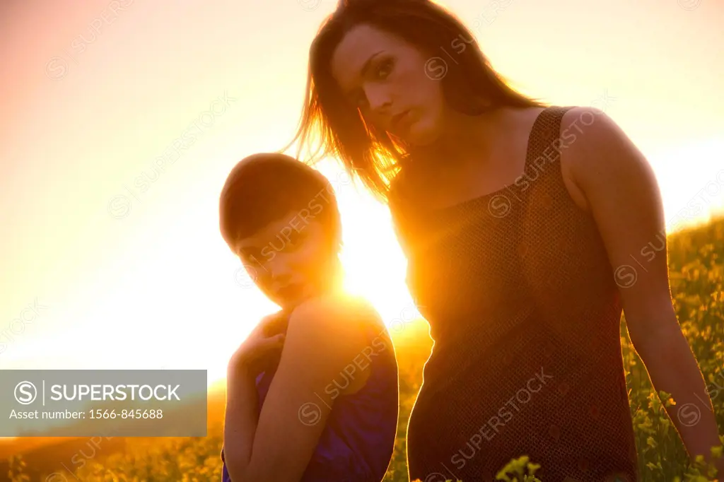 Two young caucasian women in a canola field near Spokane, Washington, USA.