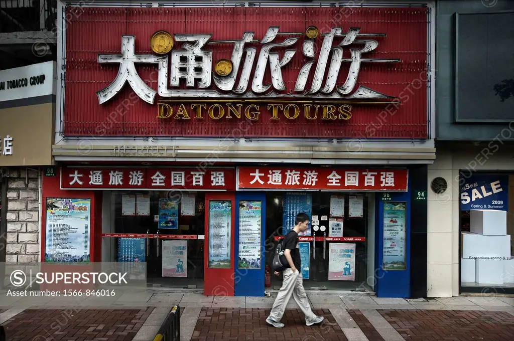Man walk in front of a travel agency in Shanghai. China country
