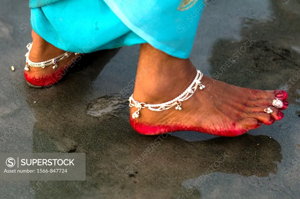 Indian woman´s feet decorated with anklet and red color.