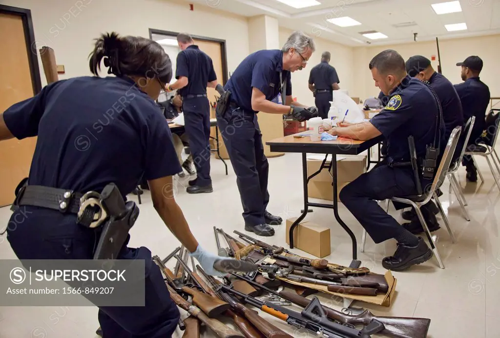 Detroit, Michigan - Police officers examine weapons turned in by residents in a gun buyback program  People were paid $25 to $200, depending on the ty...
