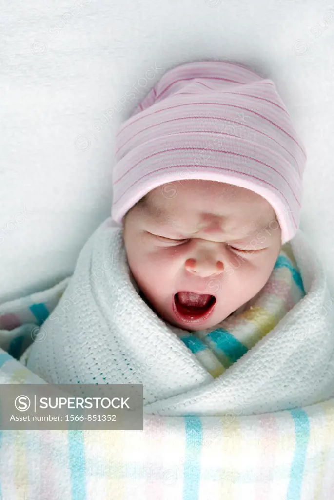 A newborn baby swaddled in blankets