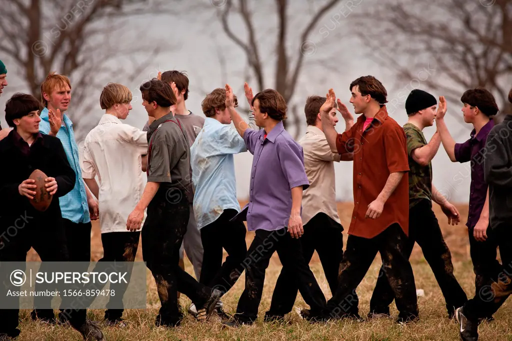 Amish play football in a farm field during the Annual Mud Sale to support the Fire Department in Gordonville, PA