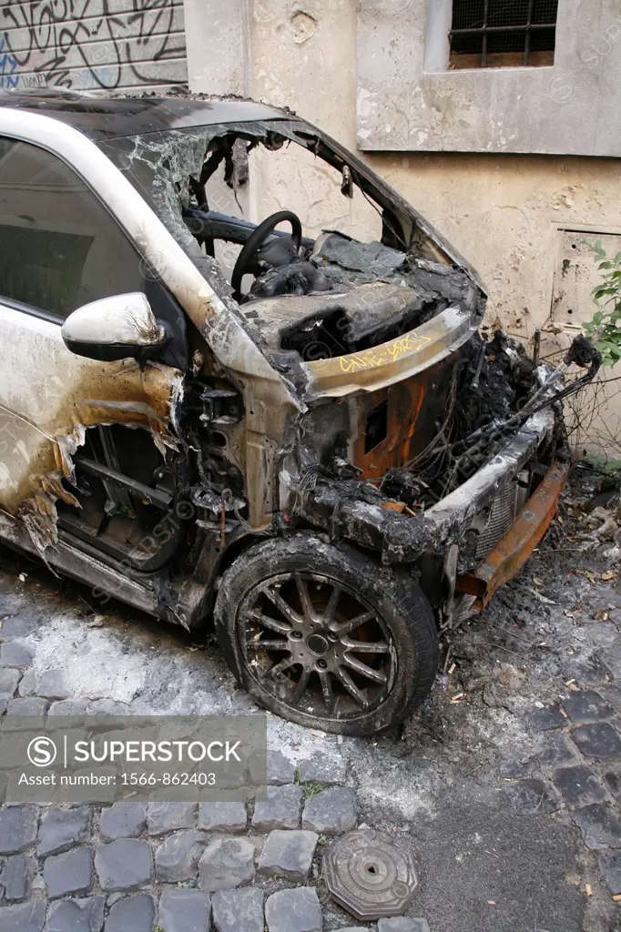 burned smart car in street in trastevere district rome italy