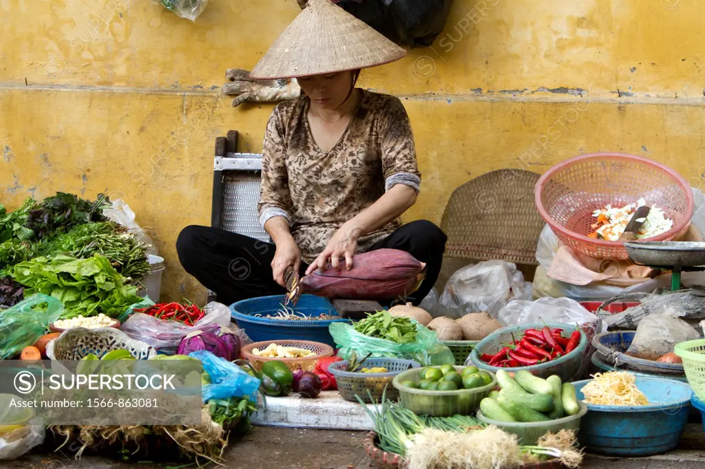 Woman selling fruits and vegetables on the street market in old Hanoi city.