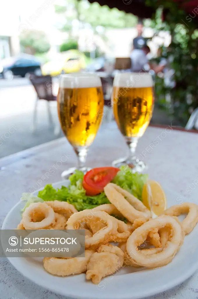 Fried squids serving and two glasses of beer in a terrace. Madrid, Spain.