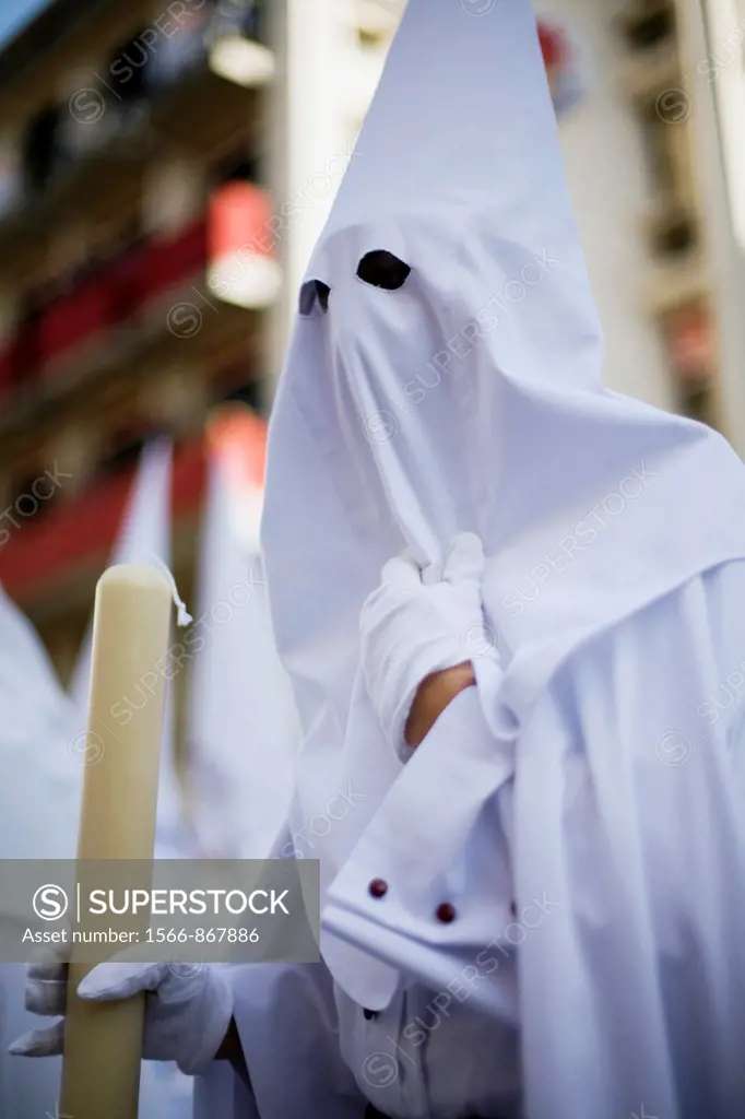 Hooded penitent bearing a candle, Palm Sunday, Seville, Spain