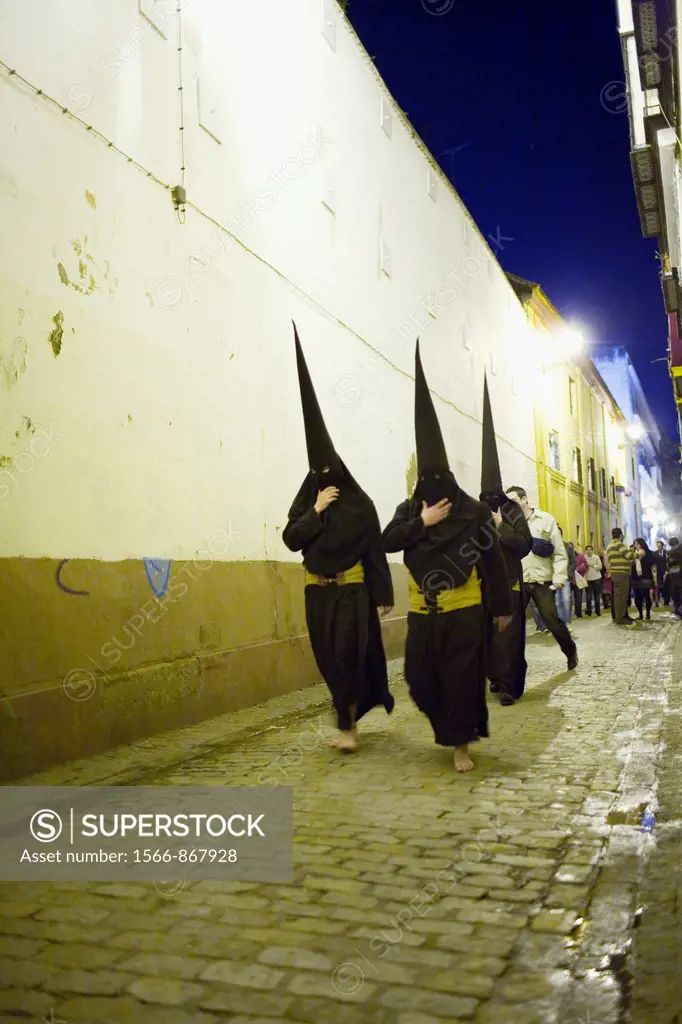 Hooded penitents going to the church before a Holy Week procession, Seville, Spain