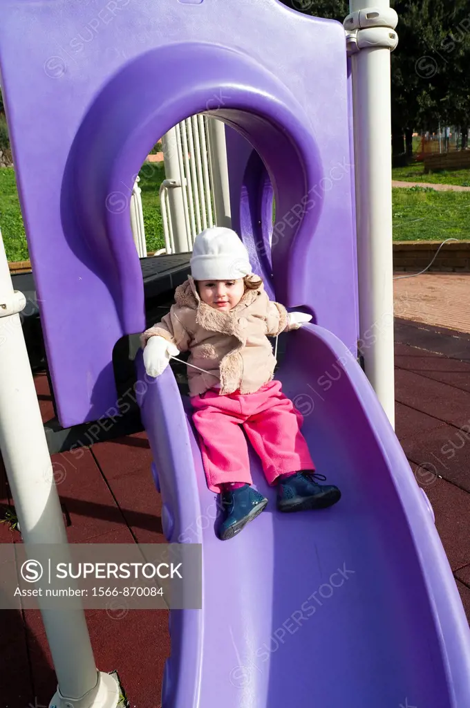 Little child playing on a playground slide