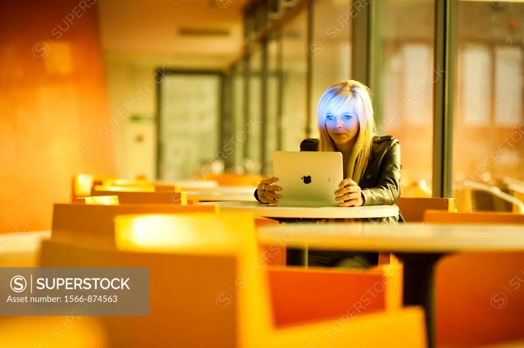 A 16 year old blonde haired slim teenage girl, using an Apple iPad, UK