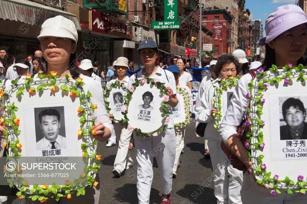 Carrying banners and signs members of Falun Dafa Falun Gong from around the world parade through the streets of Chinatown in New York Practitioners of...