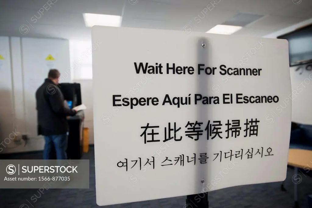 A sign instructs voters, in English Spanish, Chinese and Korean, to wait for the scanner, to cast their ballots in New York in Washington Heights on e...