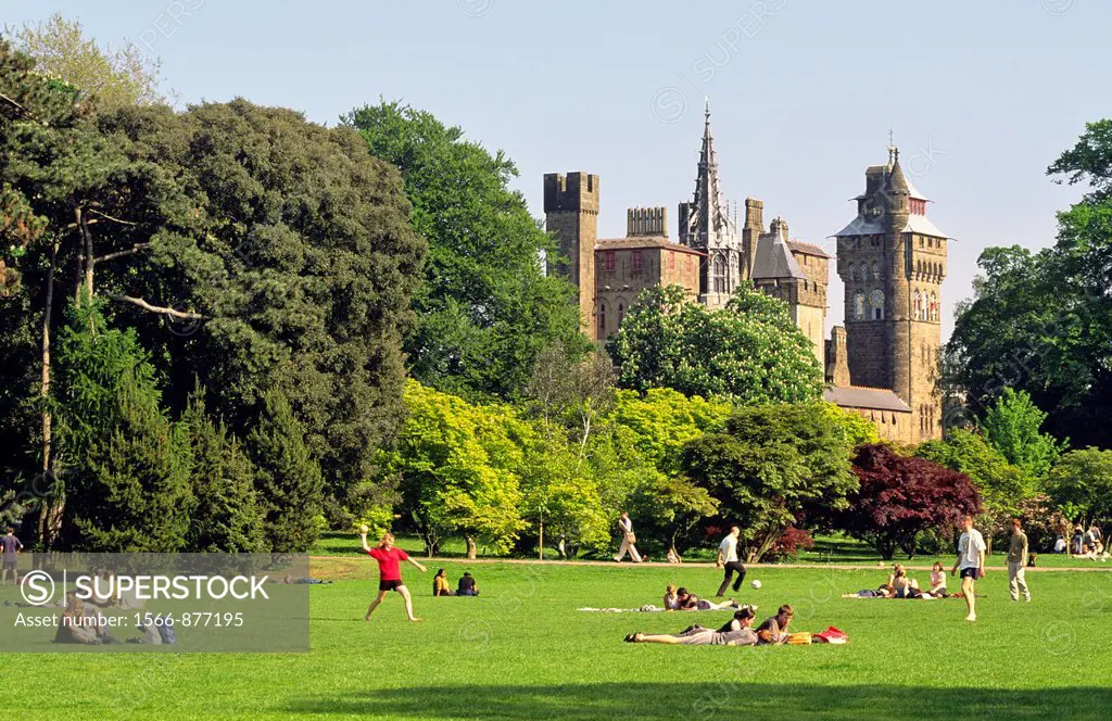 Cardiff Castle rises behind Bute Park  Cardiff city centre, Wales, UK  Students and lunch break office workers relaxing  Summer