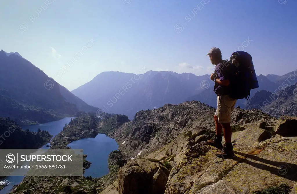 hiker looking `Estanys de Barbs´ and `Estanys de Munyidera´ Barbs and Munyidera lakes,Aigüestortes i Estany de Sant Maurici National Park,Pyrenees, Ll...