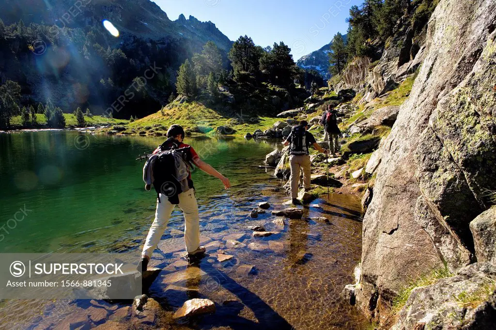 Trippers in Redon lake,Colomèrs cirque,Aran Valley, Aigüestortes and Estany de Sant Maurici National Park,Pyrenees, Lleida province, Catalonia, Spain