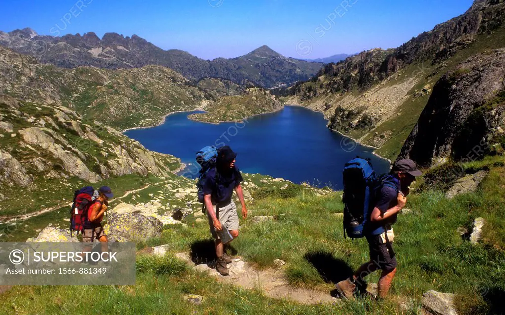 Hikers in `Estany Obago´, Obago lake,Colomèrs cirque,Aran Valley, Aigüestortes and Estany de Sant Maurici National Park,Pyrenees, Lleida province, Cat...