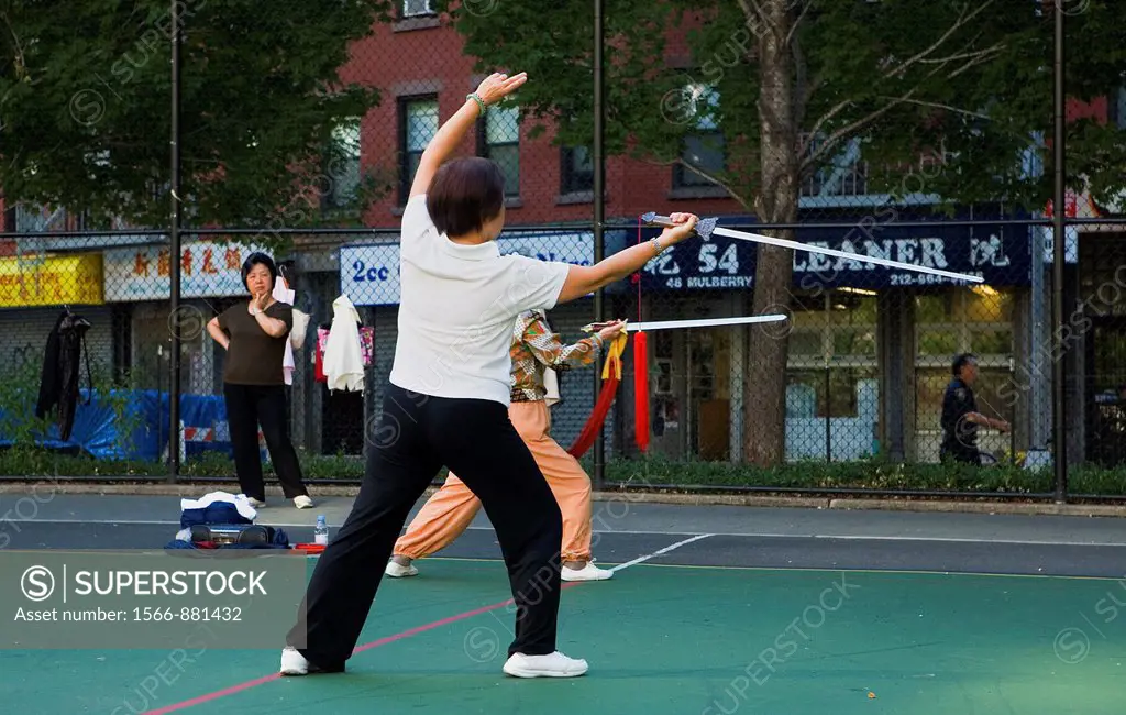 Chinese people performing early morning Sword exercises in Columbus Park,New York City, USA
