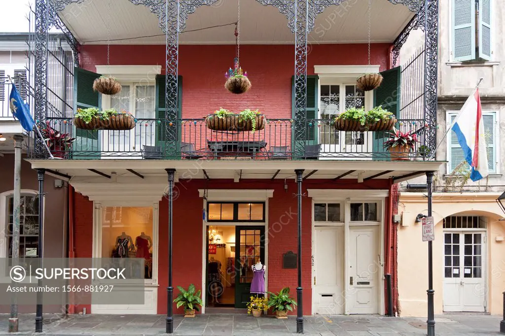 Upscale dress shop under balcony with decorative wrought iron railings in the French Quarter of New Orleans, LA