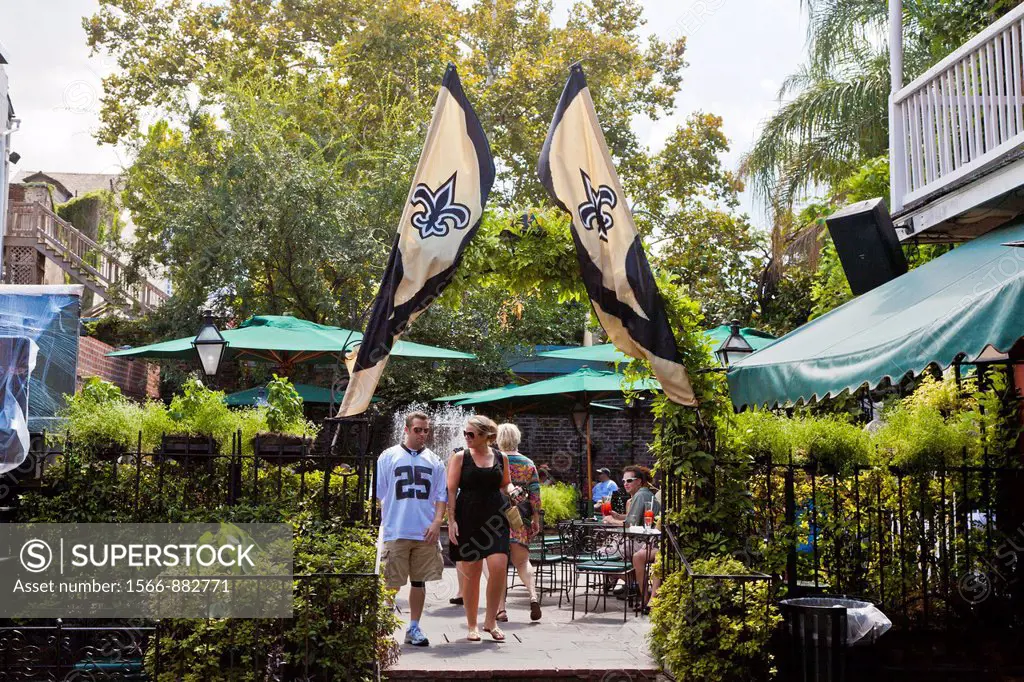 Guests leaving the Courtyard Restaurant under flags of the New Orleans Saints football team at Pat O´Brien´s in the French Quarter of New Orleans, LA