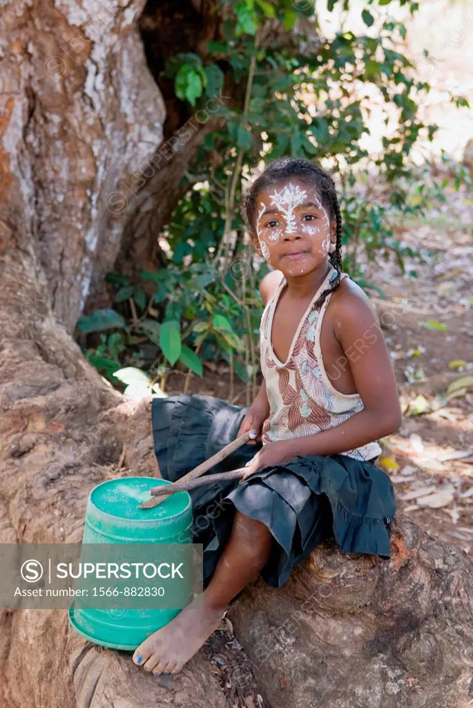 little girl playing drum, Ampasipohy, Nosy Be island, Republic of Madagascar, Indian Ocean