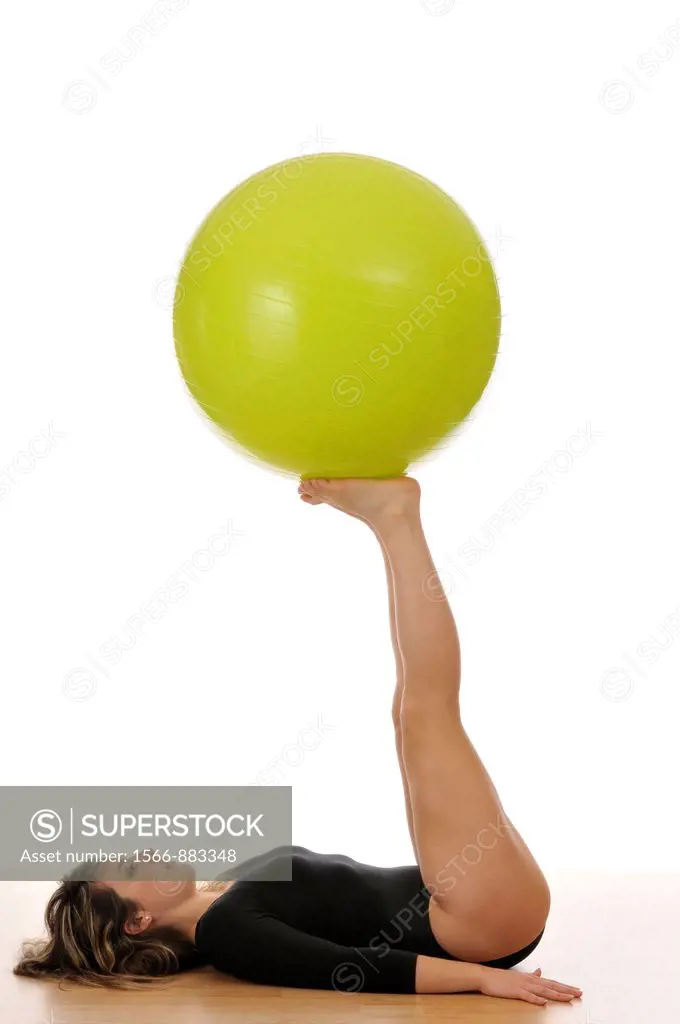 young woman doing exercise, gymnastics, with a large green ball, giant ball