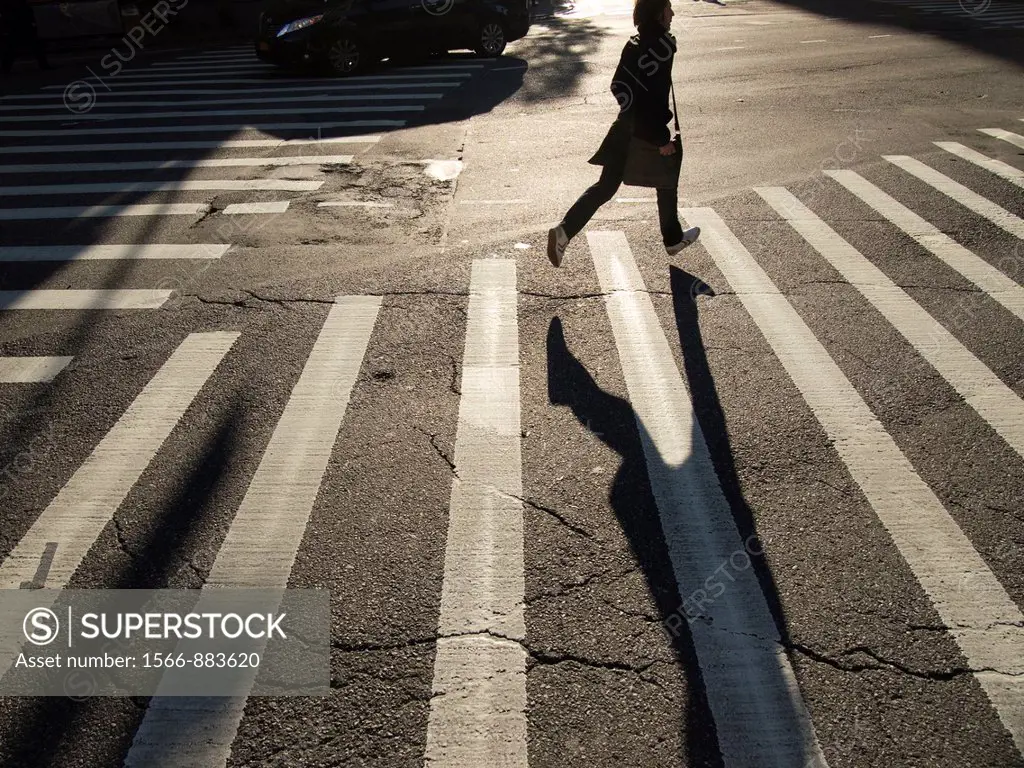 A young woman runs across a crosswalk in New York, New York, United States