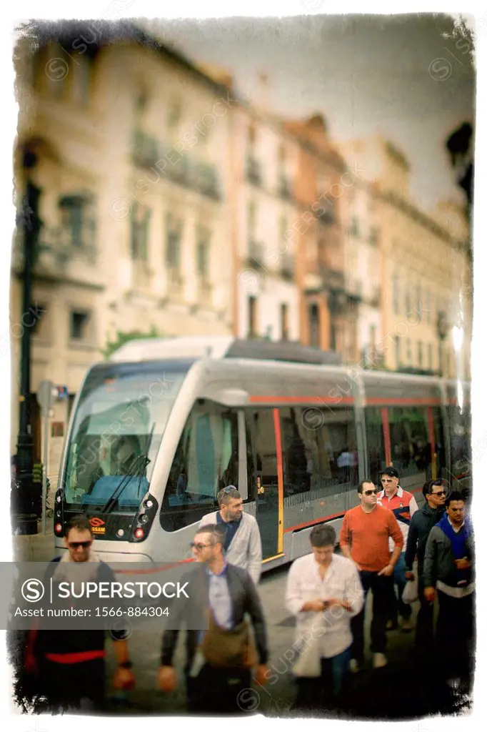 Pedestrians and streetcar on Constitution Avenue, Seville, Spain  Taken with tilted lens to get shallower depth of field and digitally edited to look ...