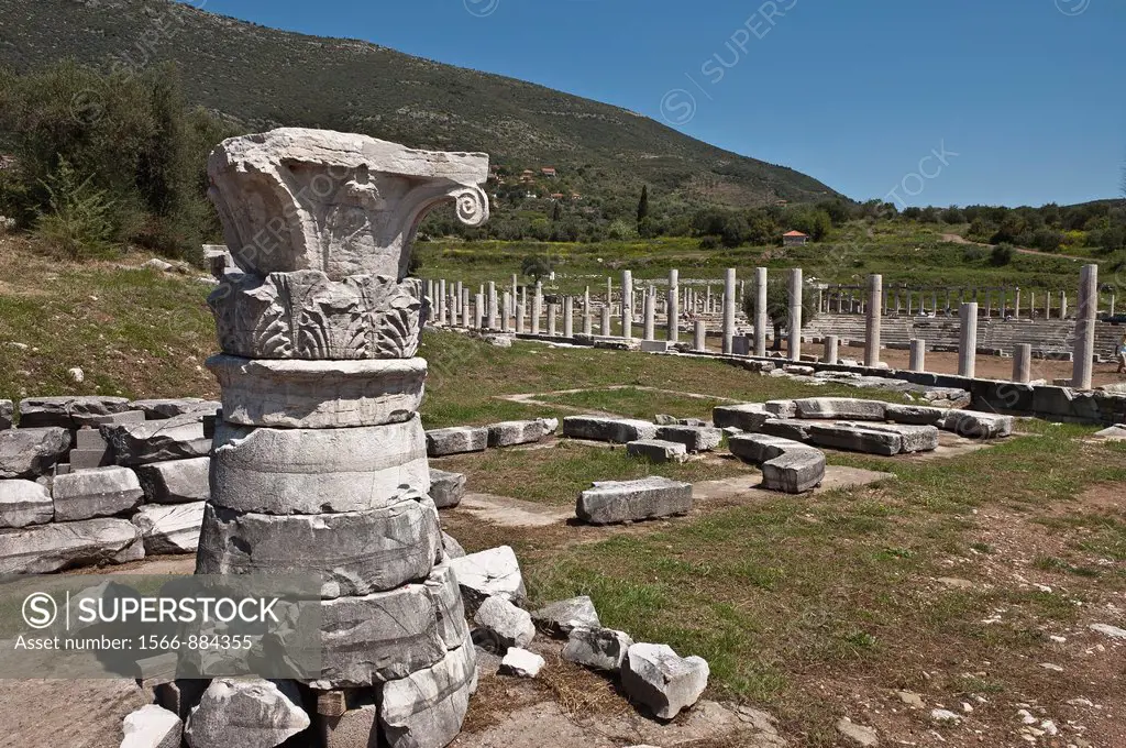The remains of a conical temple roof and an old capital at Ancient Messene Ithomi with the stadium in the background, Messinia, Southern Peloponnese, ...