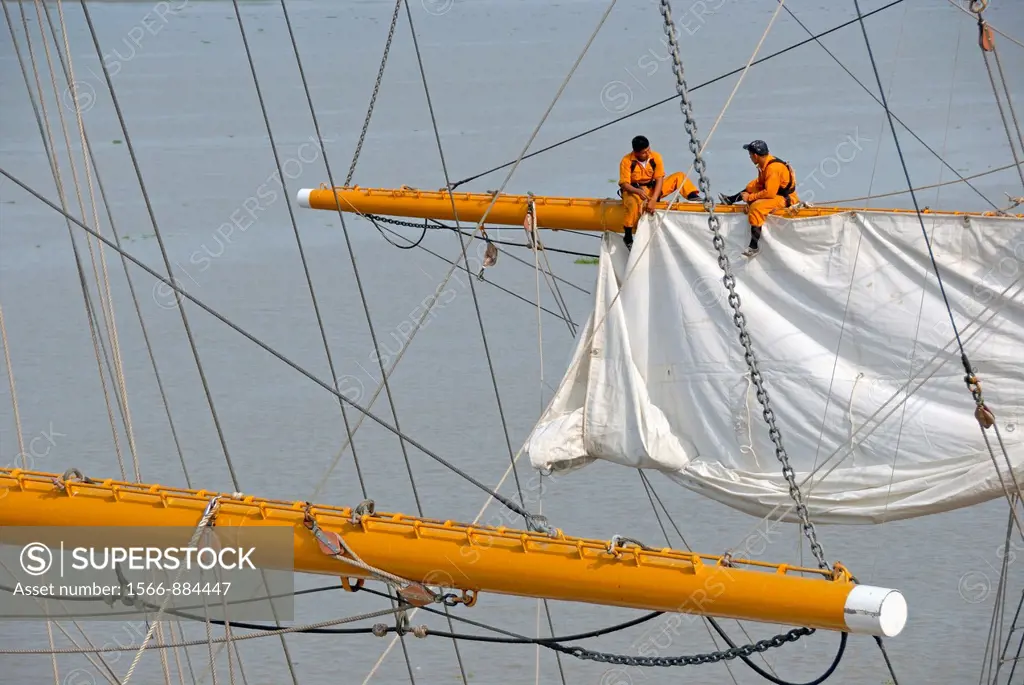 Men repairing a sail of the three-masted sailboat on Guayas river, used as a training ship for Ecuadorian Navy cadets, Guayaquil, Ecuador