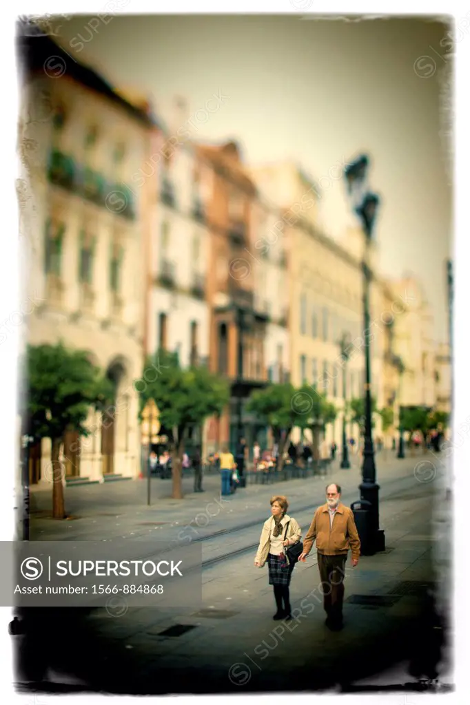 Elderly couple walking on Constitution Avenue, Seville, Spain  Taken with tilted lens to get shallower depth of field and digitally edited to look lik...