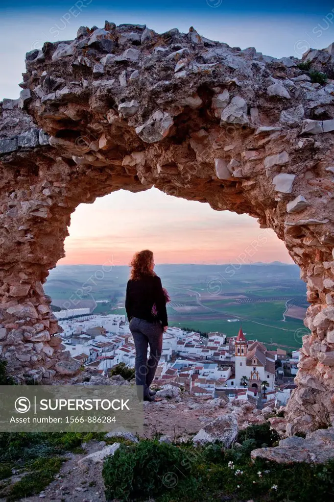 Young woman at sunset with views of Teba and his church, from the ruins castle  Teba, Malaga, Andalusia, Spain