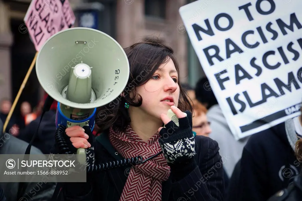 Young woman with a loudhailer demonstrating at a rally against racism and facism, Street demonstartion in Glasgow, Scotland, UK
