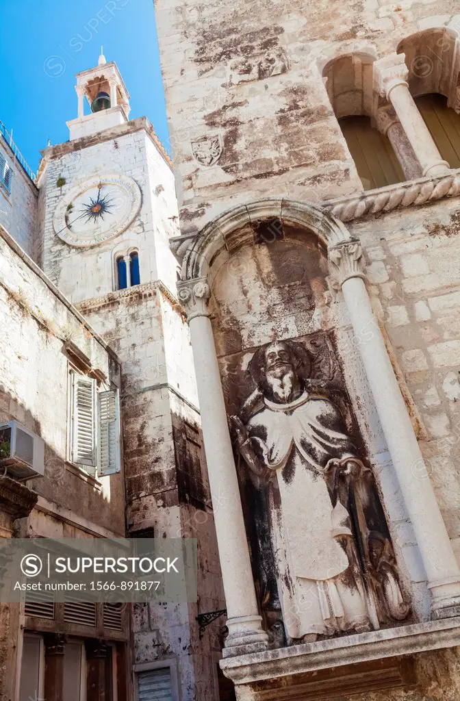 A statue of a religious figure carved into the wall of a building at the corner of a street in Split, Croatia