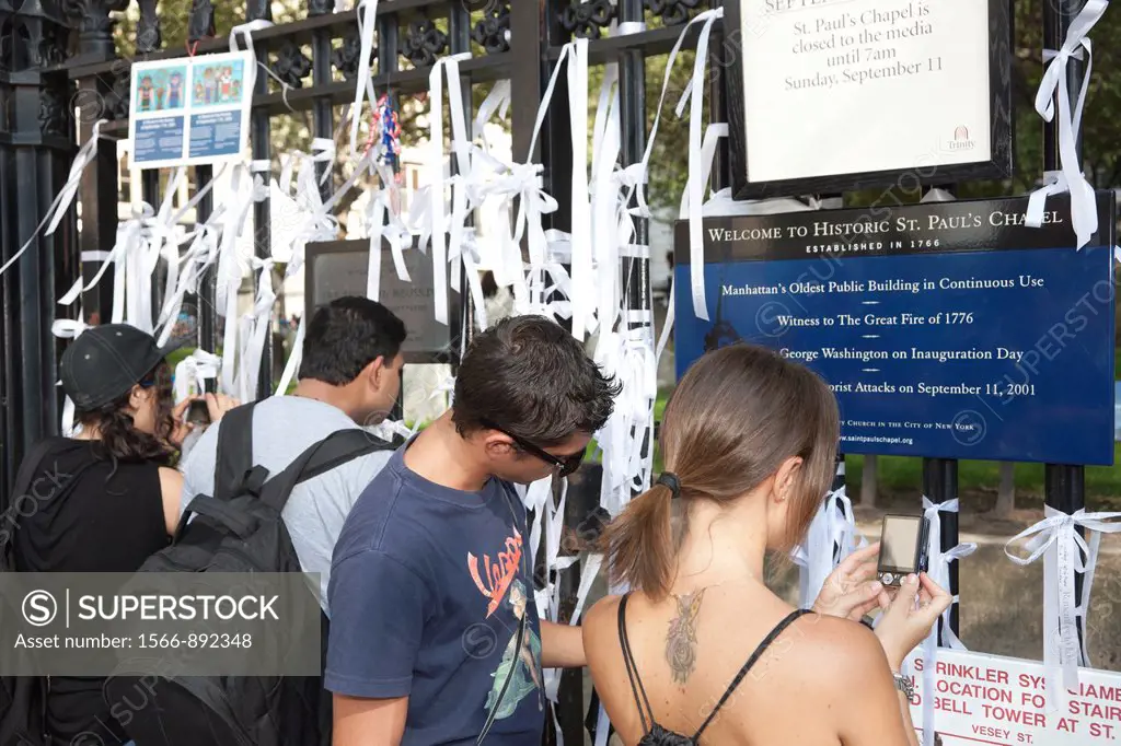 Visitors read and take photographs of white ribbons of remembrance on the fence surrounding St. Paul´s Chapel on Church Street, across from the World ...