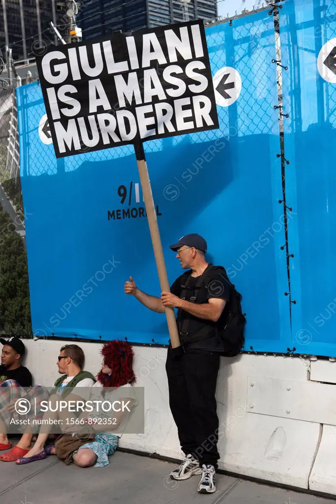 A protester holds a sign alleging ´Giuliani is a mass murderer´ near the World Trade Center site in New York City, New York, USA