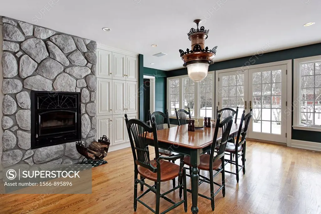 Dining room with stone fireplace and wall of windows