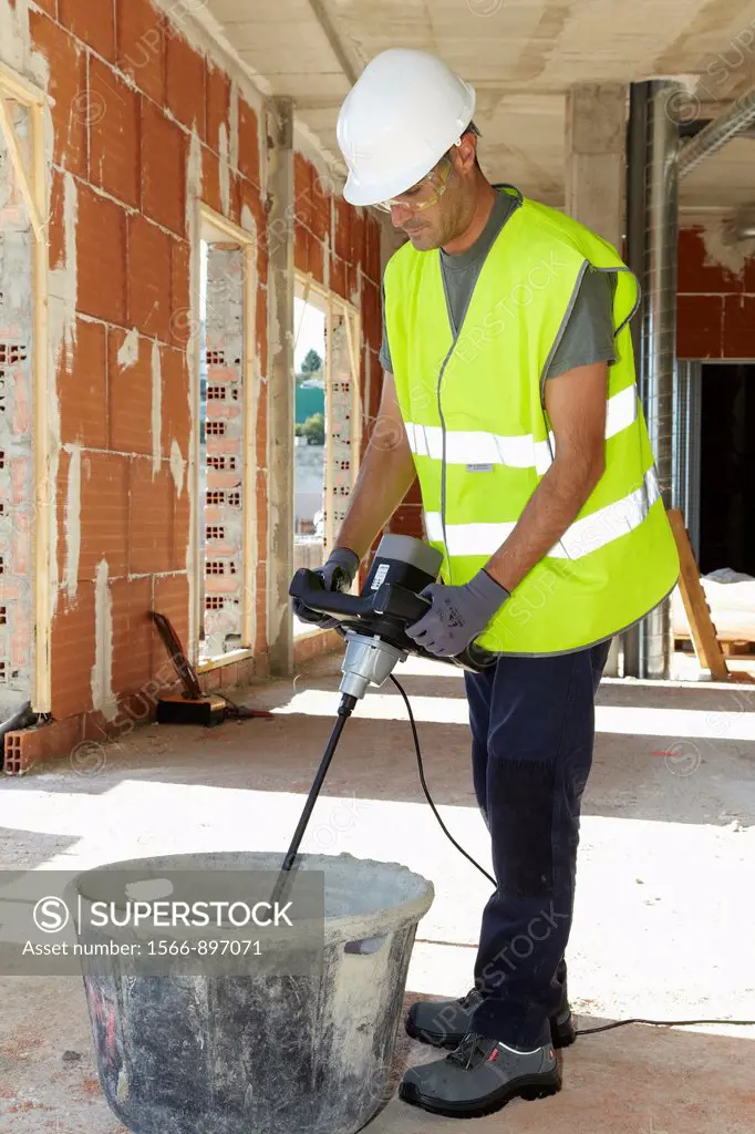 Construction worker making mortar with mixer, Building machinery, Donostia, San Sebastian, Gipuzkoa, Basque Country, Spain